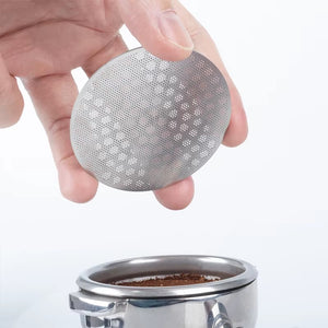 Perforerad puck screen i handen ovanför en portafilter